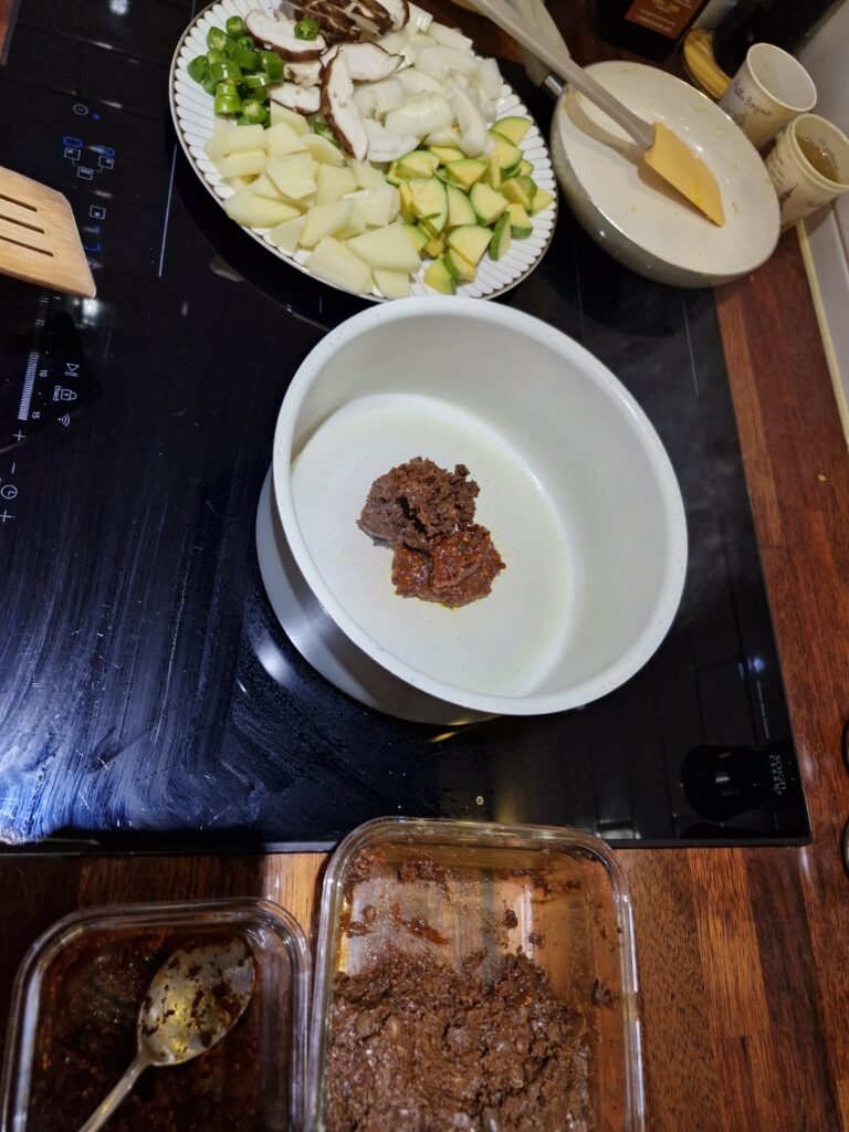 Adding oil and soybean paste to the pot