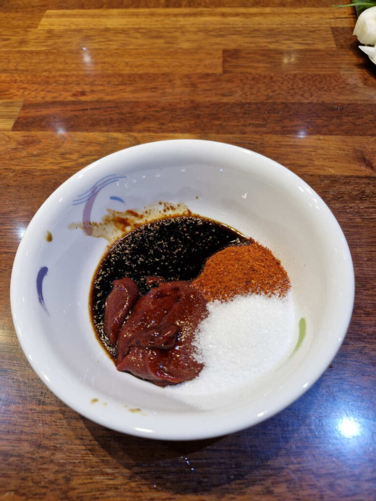 Mixing the red base sauce in a small bow