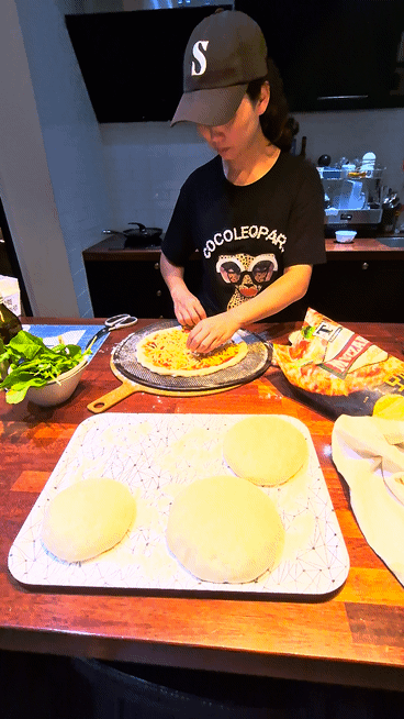 My wife adding fresh toppings to a homemade pizza dough