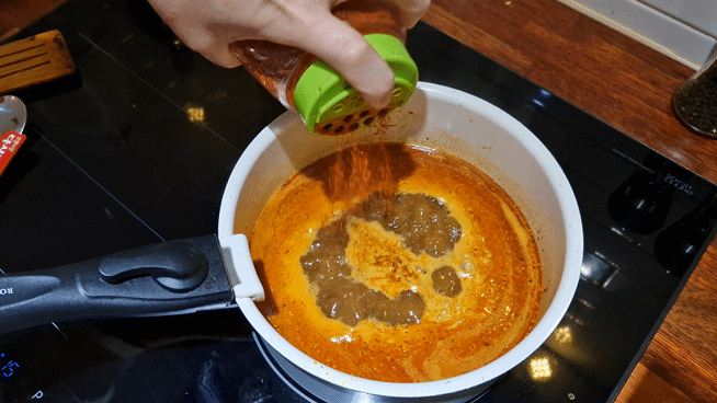 Adding Gochugaru (Red chili powder) to the broth