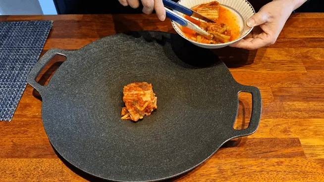 Putting 200g of kimchi into the bottom of a pot