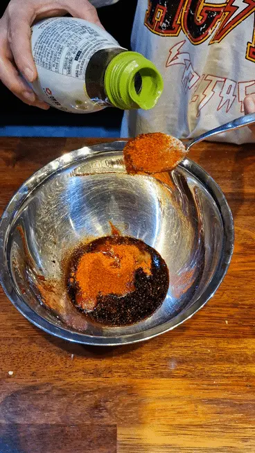 Spoonful of Yondu (Korean liquid seasoning) being added for depth