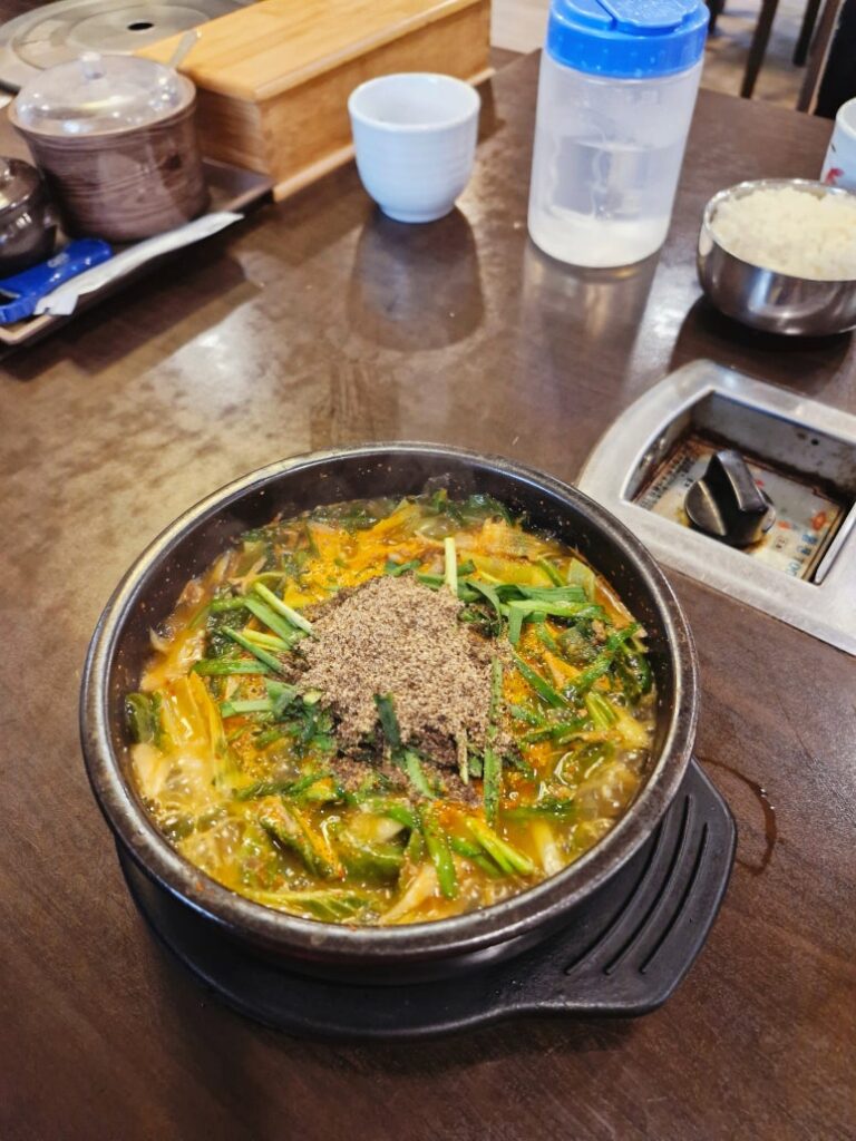A rich and hearty Korean black goat soup (Heuk-yeom-so Tang) boiling in a pot.