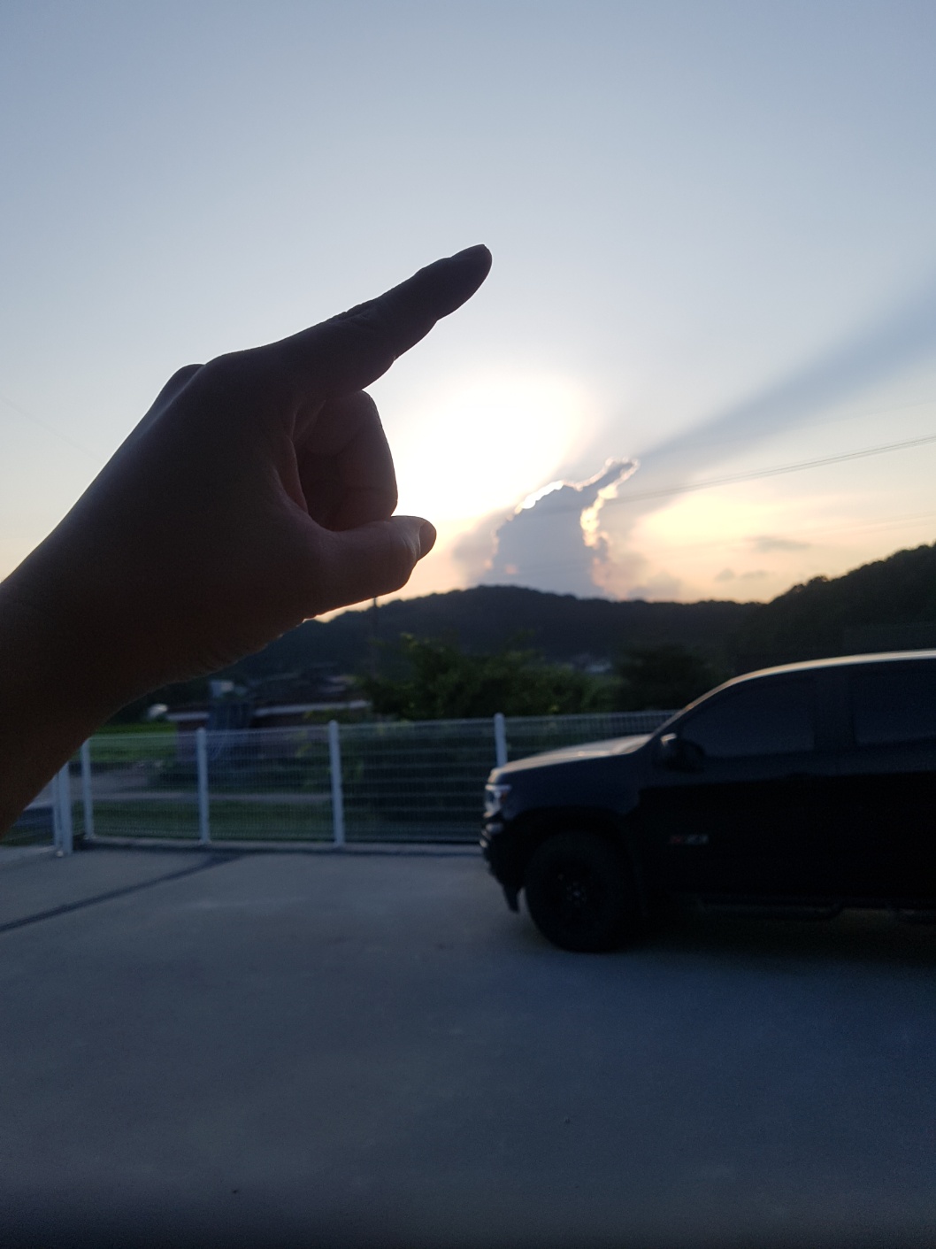 A man trading his BMW X6 for a Chevy Colorado at sunset in Paju.