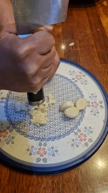 Crushing fresh garlic cloves with a mortar and pestle