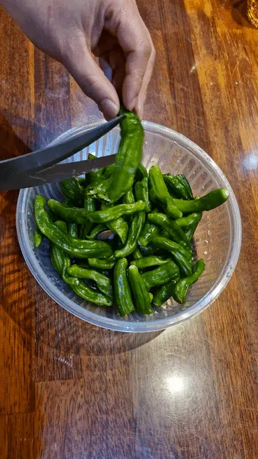 Cutting shishito peppers in half with scissors