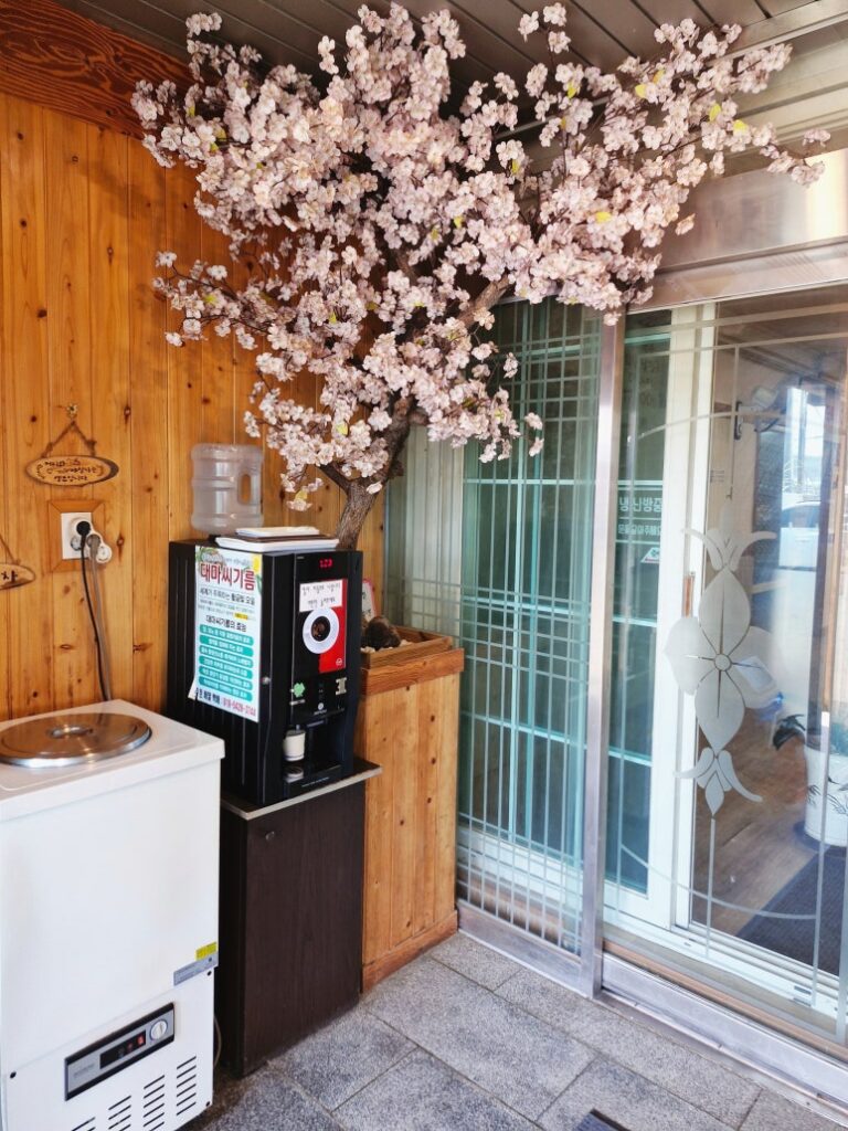 Self-service drink station with free coffee and plum tea at the entrance.