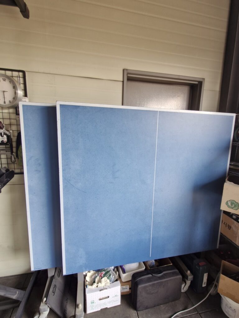 Multipurpose home gym layout featuring a table tennis table and strength equipment