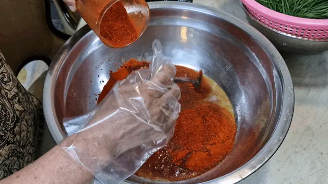 Adding Korean red pepper flakes (Gochugaru)