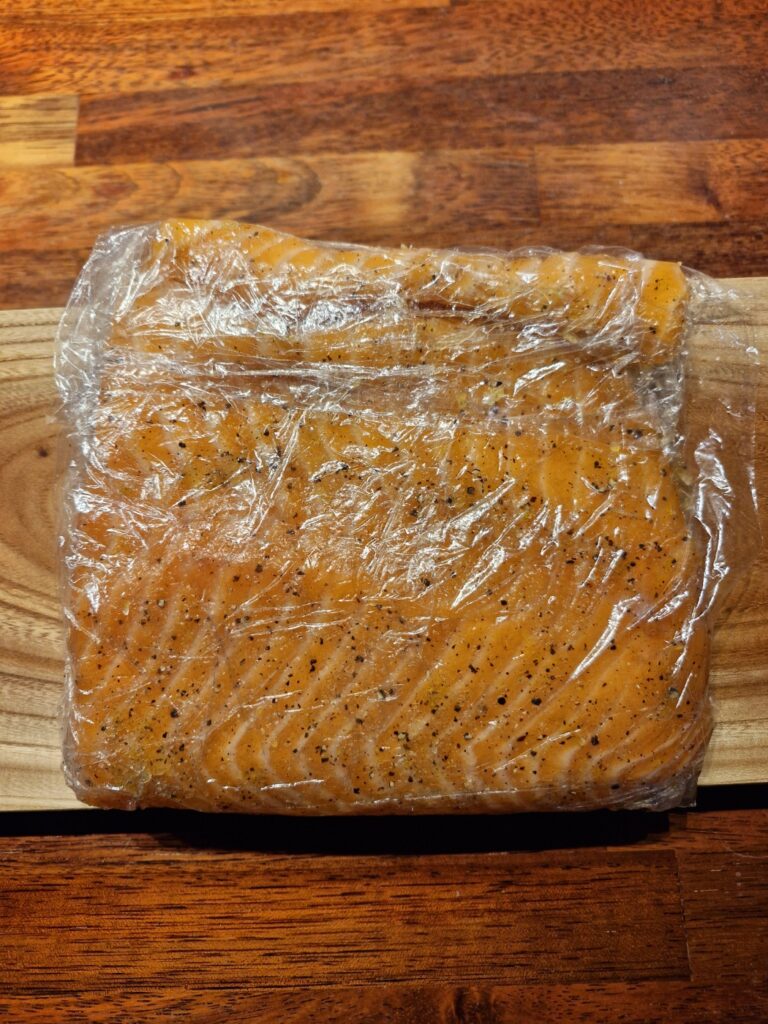 Fresh salmon covered in lemon zest, dill, salt, and pepper