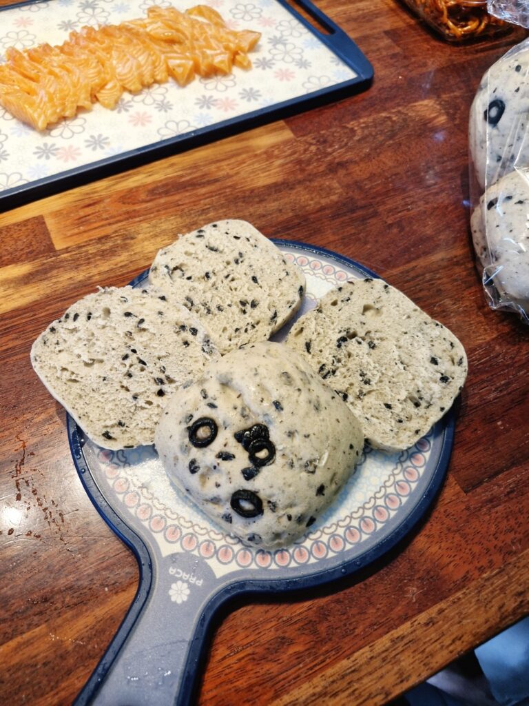 Spreading a thick layer of cream cheese on the bread
