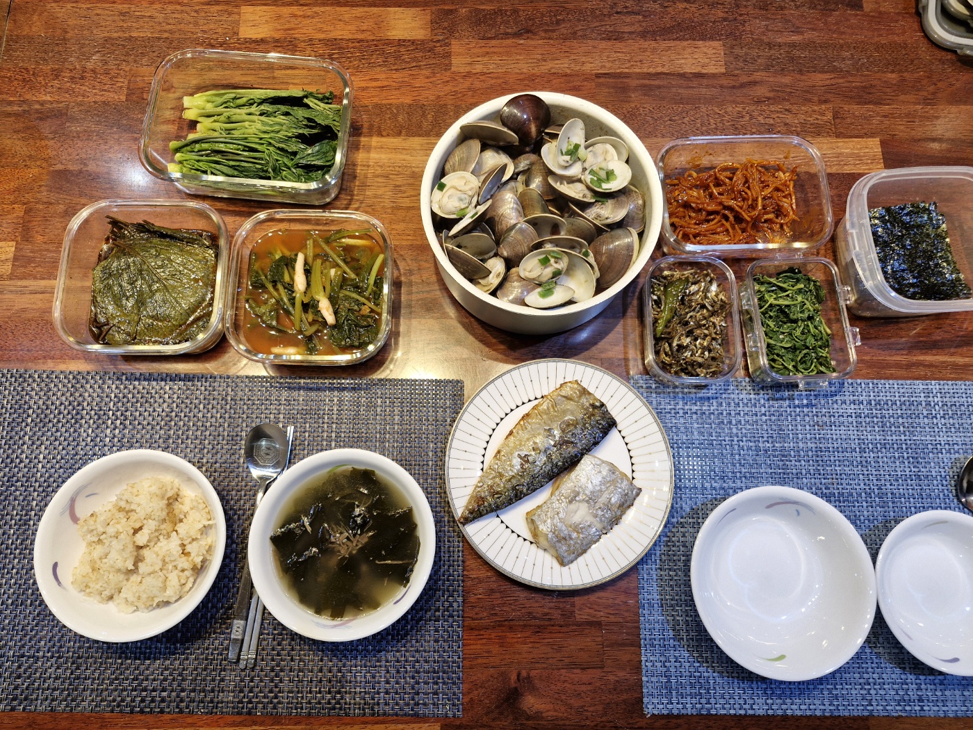 Top view of steamed clams with beer, butter, and garlic in a pot garnished with red chilies and scallions.