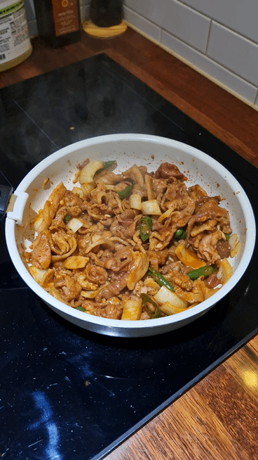 Glistening, fully cooked Jeyuk-bokkeum in the wok, ready to serve