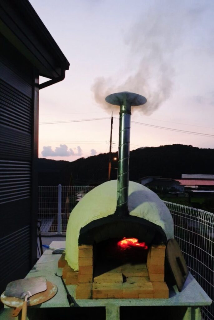 Testing the wood-fired pizza oven with a blazing fire inside to check performance