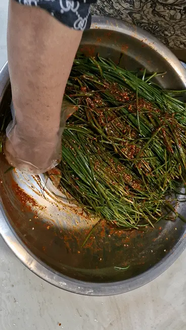 Gently tossing chives with the seasoning
